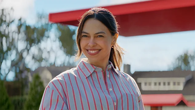 Close-up of a woman in front of AFI's red roof'