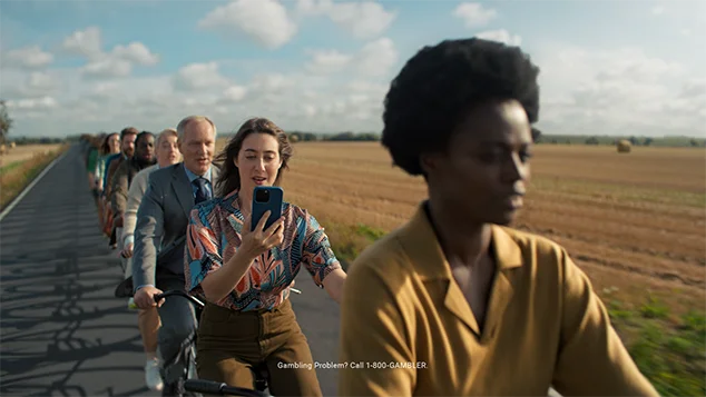 A woman on the same tandem is looking at her phone.